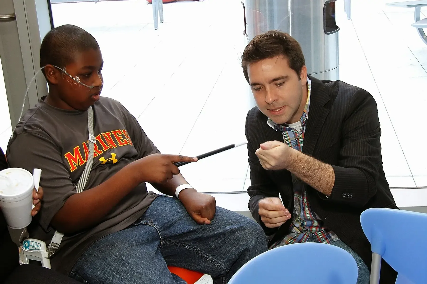 Matt performing close-up magic for an amazed boy at Children's Hospital.