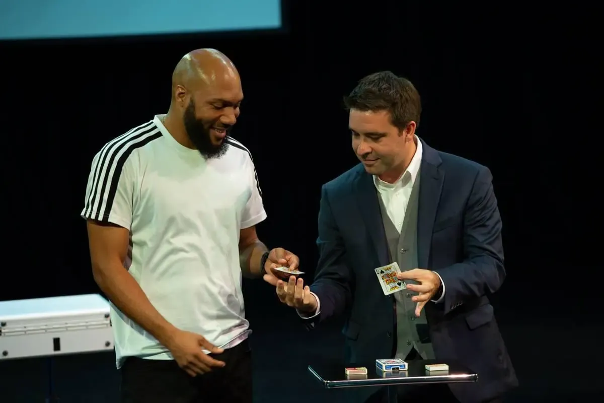 Matt showing cards to a guest on stage at a corporate show