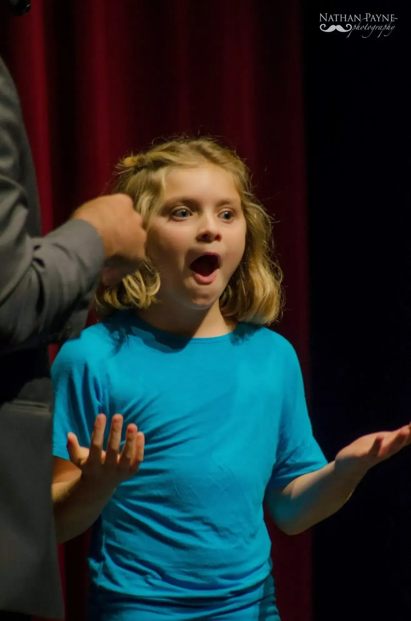 A young girl's amazed reaction during the family stage show.