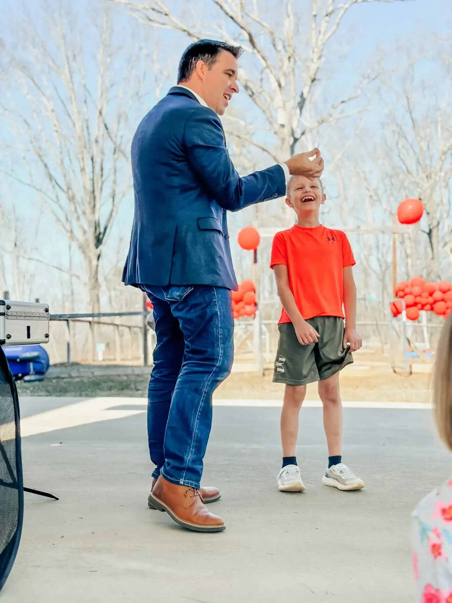 Matt performing outdoors for a boy in an orange shirt