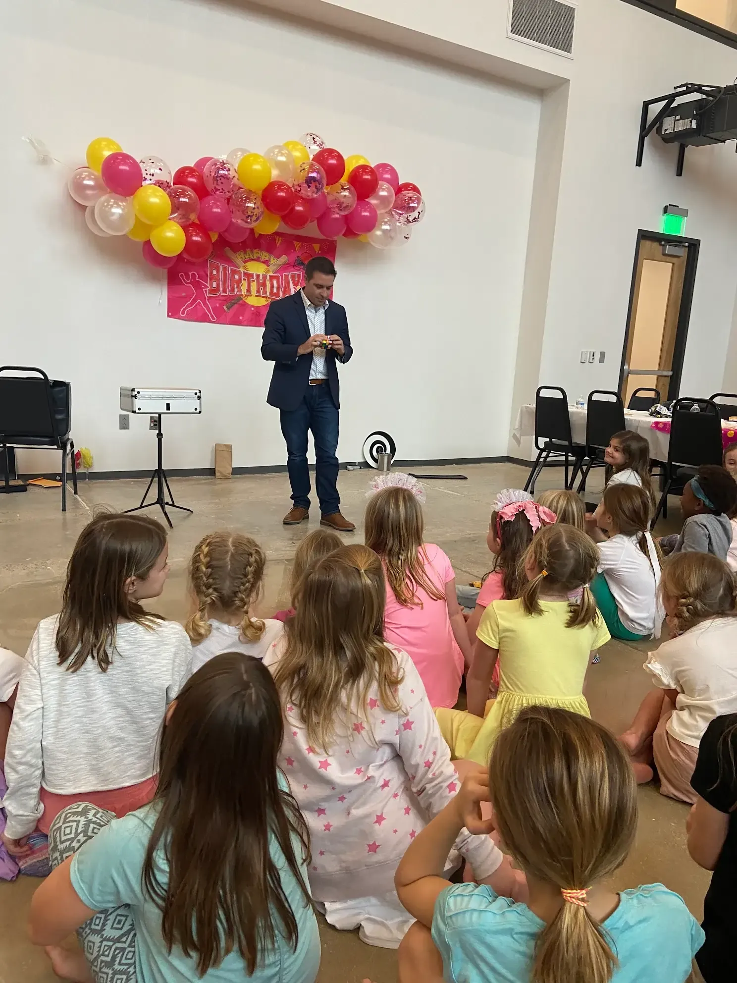 Matt performing magic for a group of girls at a birthday party.
